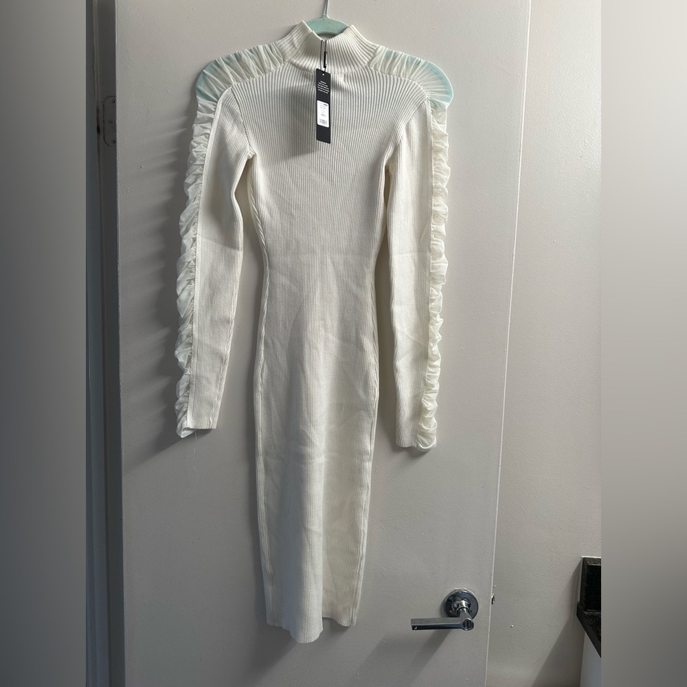 Brand new with light makeup stain on dress that’s white with ruffle sleeve.